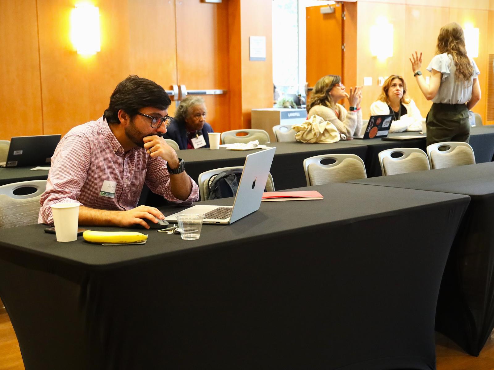 Flash-funding award recipient Akram Al-Turk, a research associate at the Moritz Center for Societal Impact at the Steve Hicks School of Social Work, works on his grant proposal at the WCWH Symposium, February 7.