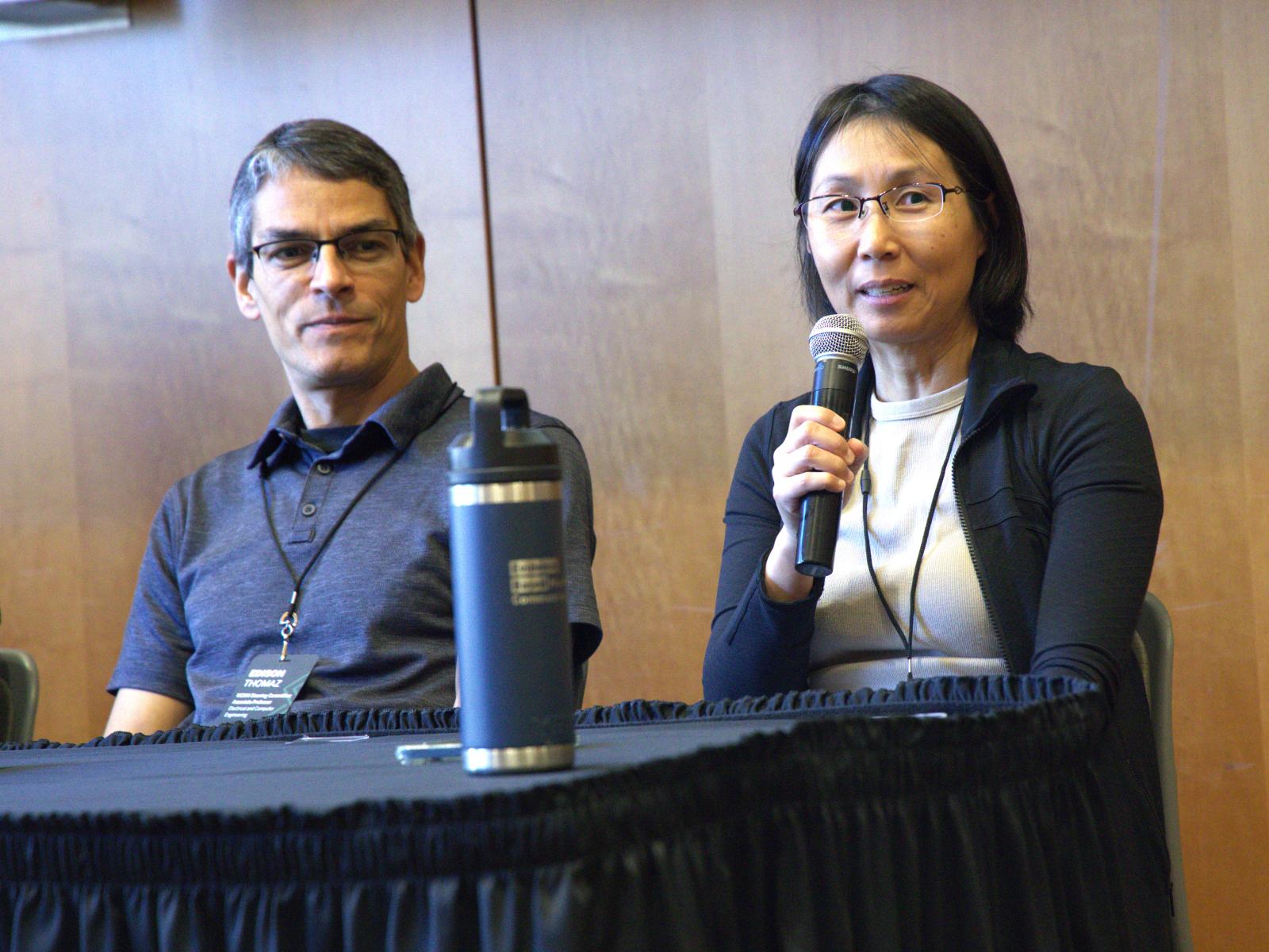 At the Whole Communities–Whole Health Symposium at UT Austin on February 6, 2026, Yan Zhang (right) speaks while Edison Thomaz (left) looks on.
