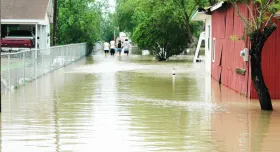 Family walks home through flood waters after Dolly